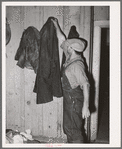 John Frost, farmer in Tehama County, California, donning his work overcoat