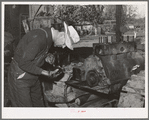 Paul Erickson, owner of forty acres of land in Yuba County, California. He is working on his tractor. He has diversified fruit farm with a federal land bank loan and production credit loan. (see full title in notes section)