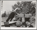 Farmer looking at the tank of tractor to see if it needs fuel. Box Elder County, Utah