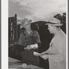 Freight train conductor talking to railroad man who was in charge of shipping livestock. Cimarron, Colorado
