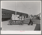 Pulling carload of express packages away from train immediately after the arrival of the morning train. Montrose, Colorado