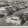 Workers' automobiles parked near the airplane factories. San Diego, California. Providing parking space for automobiles and getting the cars in and out at shift changing time have been big problems