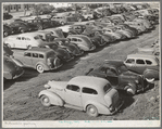 Workers' automobiles parked near the airplane factories. San Diego, California. Providing parking space for automobiles and getting the cars in and out at shift changing time have been big problems