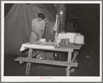 Carpenter's wife setting the table in front of their tent home. Mission Valley, California, which is about three miles from San Diego. These people followed construction work in Texas, Louisiana, Illinois and Arizona. (see full title in "notes" section)
