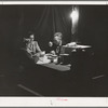 Carpenter, his wife and daughter eating supper in front of their tent-home. Mission Valley, California, about three miles from San Diego