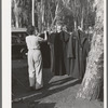 Carpenter's wife hanging up coat to dry. Mission Valley, California, which is about three miles from San Diego. This family is living in a tent because of inability to find suitable housing. A heavy rain the night before had everything wet in their tent