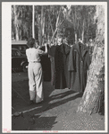 Carpenter's wife hanging up coat to dry. Mission Valley, California, which is about three miles from San Diego. This family is living in a tent because of inability to find suitable housing. A heavy rain the night before had everything wet in their tent