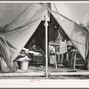 Construction worker's wife ironing in her tent home. Mission Valley, California, about three miles from San Diego