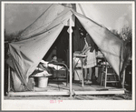 Construction worker's wife ironing in her tent home. Mission Valley, California, about three miles from San Diego