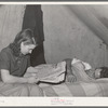 Concrete worker resting while his wife looks for apartments in the want ads. He works the night shift. They have been unable to find a reasonably priced apartment and are living in a tent. They are from Washington. Pacific Beach, California