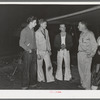 Three boys who have come down from Los Angeles looking for work talking to a friend who is already employed. San Diego, California