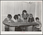 Six children of carpenter from Hobbs, New Mexico, reading the funny papers. This family of eight are living in two small rooms in tourist court because they can find nothing larger at a reasonable price. Corpus Christi, Texas