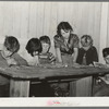 Six children of carpenter from Hobbs, New Mexico, reading the funny papers. This family of eight are living in two small rooms in tourist court because they can find nothing larger at a reasonable price. Corpus Christi, Texas