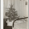 Baby and Christmas tree in corner of living room in home of construction workman. This family came to Corpus Christi from northwest Texas eight months ago