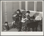 Wives of farm workers living at the Yuba City FSA camp sewing in the community building of the camp. Yuba City, California