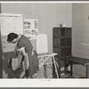 Wife of farmer living at the Yuba City FSA (Farm Security Administration) farm workers' camp. Yuba City, California. She is sewing and pressing in the community building