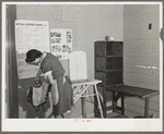 Wife of farmer living at the Yuba City FSA (Farm Security Administration) farm workers' camp. Yuba City, California. She is sewing and pressing in the community building