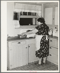 Wife of fruit farmer at her kitchen sink. Placer County, California