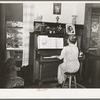 Fruit farmer's wife playing piano. Placer County, California. Because they have not changed the variety of plums and pears which they raise to meet changed market conditions they have gone further and further into debt to the Federal Land Bank
