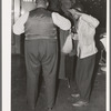 Brushing off a customer in barber shop. Southside Chicago, Illinois