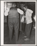 Brushing off a customer in barber shop. Southside Chicago, Illinois