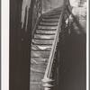 Staircase in hall of apartment buildings formerly rented to Negroes. This house is now vacant after fire. Chicago, Illinois