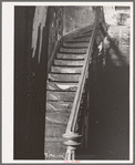 Staircase in hall of apartment buildings formerly rented to Negroes. This house is now vacant after fire. Chicago, Illinois