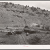 Flat cars of narrow gauge railroad loaded with logs from the surrounding mountains. Baker County, Oregon