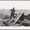 Mr. Browning screening coal which he has salvaged. He will burn the larger lumps. He is an FSA  rehabilitation borrower living at Dead Ox Flat, Malheur County, Oregon