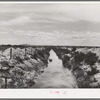Irrigation lateral ditch to provide water for farms on the Vale-Owyhee irrigation project. Notice that the piles of dirt on the sides give some indication of the relative newness of this project. Malheur County, Oregon