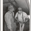 Sheep shearers on ranch in Malheur County, Oregon. The cord around the waist of man on right is used to sew up the sacks which contain wool. These sheep shearers travel in outfit of which man on left is boss, has about twenty members