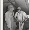 Sheep shearers on ranch in Malheur County, Oregon. The cord around the waist of man on right is used to sew up the sacks which contain wool. These sheep shearers travel in outfit of which man on left is boss, has about twenty members
