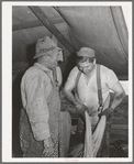Sheep shearers on ranch in Malheur County, Oregon. The cord around the waist of man on right is used to sew up the sacks which contain wool. These sheep shearers travel in outfit of which man on left is boss, has about twenty members