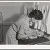 Nurse at the FSA (Farm Security Administration) migratory labor camp mobile unit, examines throat of baby in trailer-clinic. Wilder, Idaho