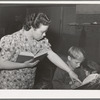 Teacher helps pupil with his reading, FSA (Farm Security Administration) camp for farm workers. Caldwell, Idaho. School is held at the camp because of lack of room in city schools