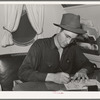 Camp manager in trailer office at the FSA (Farm Security Administration) migratory labor camp mobile unit. Wilder, Idaho