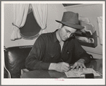 Camp manager in trailer office at the FSA (Farm Security Administration) migratory labor camp mobile unit. Wilder, Idaho