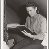 Daughter of farm worker reads her Bible. FSA (Farm Security Administration) migratory labor camp mobile unit. Wilder, Idaho