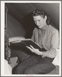 Daughter of farm worker reads her Bible. FSA (Farm Security Administration) migratory labor camp mobile unit. Wilder, Idaho