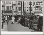 Sailors lined up against chain-rail in square in midtown. San Diego, California