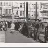 Sailors lined up against chain-rail in square in midtown. San Diego, California