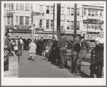 Sailors lined up against chain-rail in square in midtown. San Diego, California