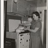 Wife of aircraft worker at the stove in her trailer home at the FSA (Farm Security Administration) camp for defense workers. San Diego, California