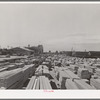 Lumber for construction work stacked in the open along Pacific Highway. San Diego, California