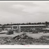 Working on jigs, with dormitories in the background at the FSA (Farm Security Administration trailer camp for defense workers. The dormitories at this project will accomodate, when finished, 952 single men. Dormitory residents will pay five dollars weekly