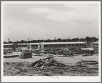 Working on jigs, with dormitories in the background at the FSA (Farm Security Administration trailer camp for defense workers. The dormitories at this project will accomodate, when finished, 952 single men. Dormitory residents will pay five dollars weekly