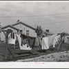 Laundry on line back of cottage of "permanent" farm worker at the FSA (Farm Security Administration) labor camp. Caldwell, Idaho. Here is a community laundry with washing machines, ironing equipment lines, etc. but some of the "permanent" workers living