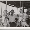 Father with his two daughters on the merry-go-round, one of the carnival attractions at the Fourth of July celebrations