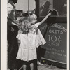 Little girls getting tickets for the merry-go-round at the carnival on the Fourth of July. Vale, Oregon