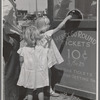 Little girls getting tickets for the merry-go-round at the carnival on the Fourth of July. Vale, Oregon